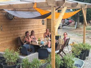 a group of women sitting at a table under an umbrella at Le Studio d'Instant Nature in Alexain