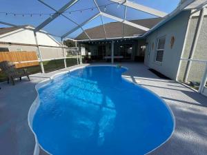 a large blue swimming pool in a house at Spacious Home w heated Pool SmartTVs Pool Table in Riverview