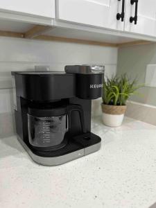 a black coffee maker sitting on a kitchen counter at Spacious Home w heated Pool SmartTVs Pool Table in Riverview