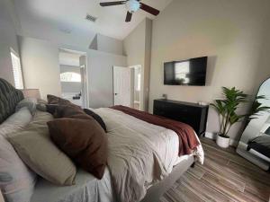 a bedroom with a bed and a flat screen tv at Spacious Home w heated Pool SmartTVs Pool Table in Riverview +38 photos