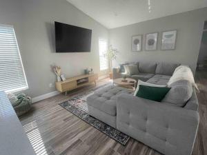 a living room with a couch and a flat screen tv at Spacious Home w heated Pool SmartTVs Pool Table in Riverview