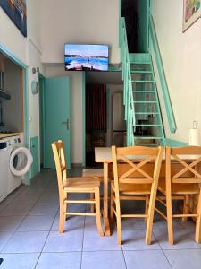 a dining room with a table and chairs and a tv at Maisonnette les oliviers in Argelès-sur-Mer