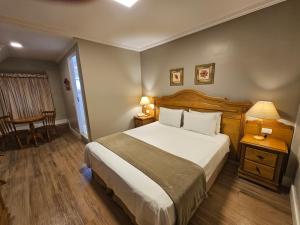 a bedroom with a bed and a table and a chair at Pousada Villaggio Itália in Campos do Jordão +51 photos