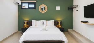 a bedroom with a white bed and a flat screen tv at Le P'tit Rubis in Le Tampon
