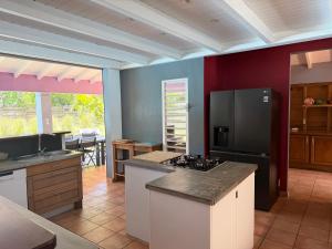 a kitchen with a refrigerator and a counter top at Villa d'architecte avec piscine in Saint-François