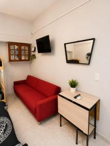 a living room with a red couch and a table at Monoambiente Ballester centro in Villa Ballester