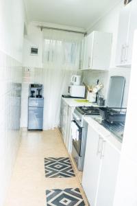 a kitchen with white cabinets and a stove top oven at The Bird House in Munyu +11 photos