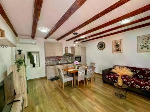a kitchen and living room with a table and a couch at Vranac Country house Šibenik in Donje Polje