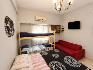 a room with two bunk beds and a red couch at Monoambiente Ballester centro in Villa Ballester