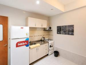 a kitchen with a white refrigerator and a sink at Monoambiente Ballester centro in Villa Ballester