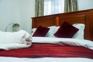 a white teddy bear laying on a bed with pillows at The Bird House in Munyu