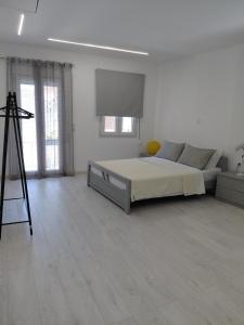 a white bedroom with a bed and a television at Sophie's Cozy Maisonette in Mytilinioí
