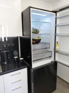 a black refrigerator with its door open in a kitchen at Sophie's Cozy Maisonette in Mytilinioí