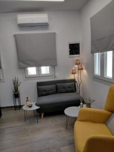 a living room with a couch and a table at Sophie's Cozy Maisonette in Mytilinioí