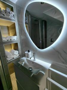 a bathroom with a sink and a mirror at Sophie's Cozy Maisonette in Mytilinioí +35 photos