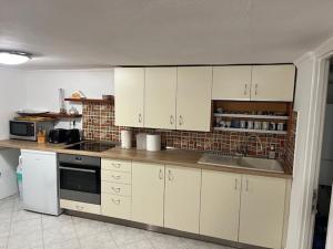 a kitchen with white cabinets and a stove top oven at Haraplak in Hajdúszoboszló