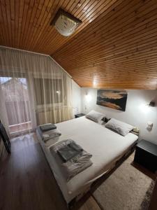 a bedroom with a large bed with a wooden ceiling at Haraplak in Hajdúszoboszló