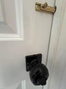 a black toilet paper dispenser on a white door at Woodland View in Redditch