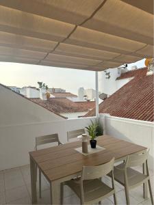 a wooden table and chairs under an umbrella at Casa Feliz in Torrox Costa