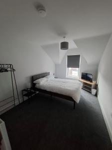 a white bedroom with a bed and a window at Alice House Long stays in Sunderland