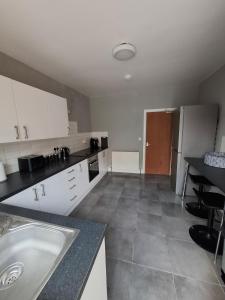 a kitchen with white cabinets and a counter top at Alice House Long stays in Sunderland