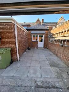 an empty courtyard of a brick building with a white door at Alice House Long stays in Sunderland