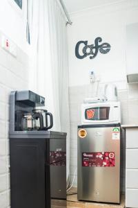 a kitchen with a coffee machine and a microwave at The Bird House in Munyu