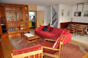 un soggiorno con divano rosso e tavolo di Ferienhaus Bifang a Feldkirch