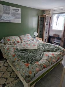 a bed with a blanket on it in a bedroom at Mon havre de paix in Blésignac