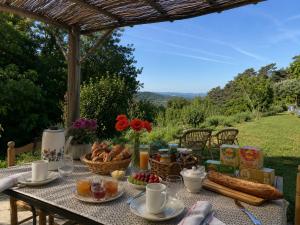 a picnic table with food on it with a view at La Clairière de l'Ange Havre de paix en Drôme des Collines in Peyrins
