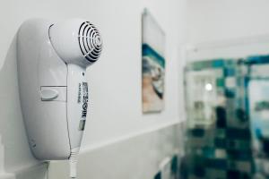 ein weißer Haartrockner an der Wand eines Badezimmers in der Unterkunft A Patedda in Favignana