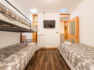 a bedroom with two bunk beds and a tv at Hostal Don Guillermo in Puerto Natales +95 photos
