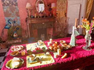 a table with food and candles on a pink table cloth at Le Chapitre in Nîmes
