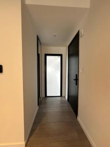 an empty hallway with two black doors and wood floors at Concepto Home in Rafaela
