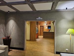a hallway with a living room with a table and a lamp at Pousada Villaggio Itália in Campos do Jordão