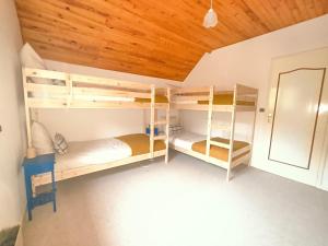 a room with three bunk beds in a room at L'évasion Monplaisir in Gère-Belesten