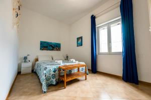 ein Schlafzimmer mit einem Bett und einem Fenster in der Unterkunft A Patedda in Favignana