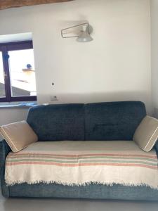 a couch sitting in a room with a window at Baita LoKa-Baita panoramica tra Lago di Como e Grigna in Bellano