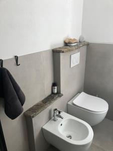 a bathroom with a white toilet and a sink at Baita LoKa-Baita panoramica tra Lago di Como e Grigna in Bellano