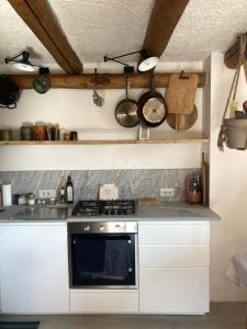 a kitchen with a stove and some pots and pans at Baita LoKa-Baita panoramica tra Lago di Como e Grigna in Bellano