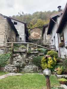 a group of stone buildings with stairs in a yard at Baita LoKa-Baita panoramica tra Lago di Como e Grigna in Bellano +14 photos