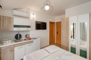 a kitchen with white cabinets and a television in a room at Guesthouse Villa Stari Grad in Herceg-Novi +171 photos