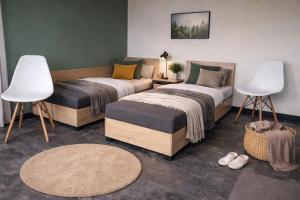 a bedroom with two beds and a table and chairs at Powidz Comfort Suites in Powidz