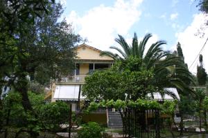 una casa con una palmera delante de ella en Gardelis Gardens, en Benitses