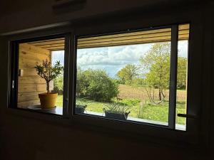 a window in a room with a view of a field at Le Studio d'Instant Nature in Alexain +4 photos