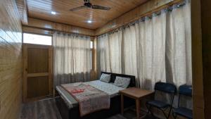 a room with a bed and a table and chairs at Kunzang Homestay in Shalkār