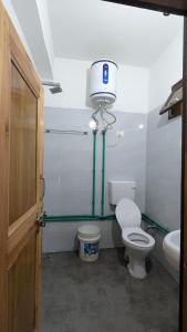 a bathroom with a toilet and a water tank at Kunzang Homestay in Shalkār