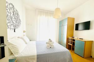 a bedroom with a bed with two stuffed animals on it at Hotel Solitude in Riccione +111 photos