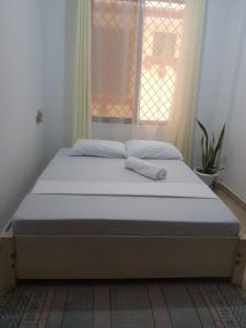 a bed sitting in a room with a window at House Stark in Kilifi