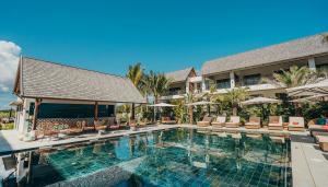 a pool at a resort with chairs and umbrellas at Tropical - Resort - Spa - Pool & Garden in Grand-Baie